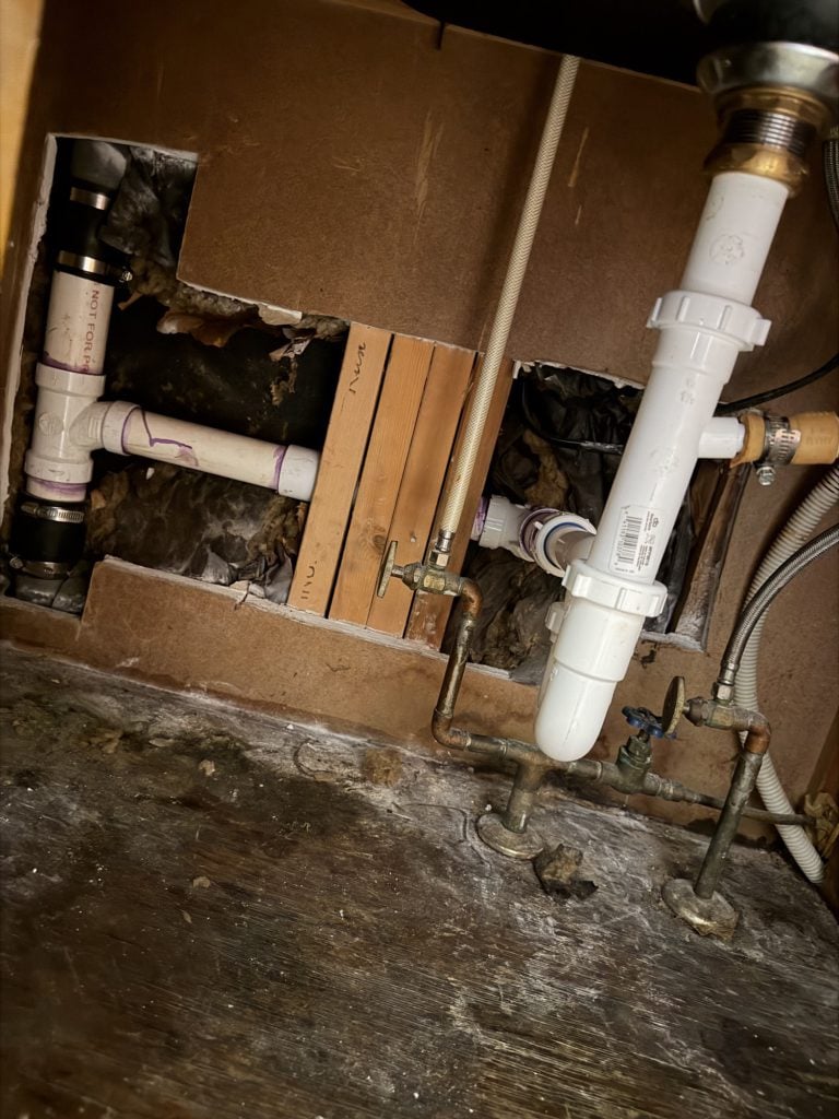 Repiped drain and supply lines under a kitchen sink